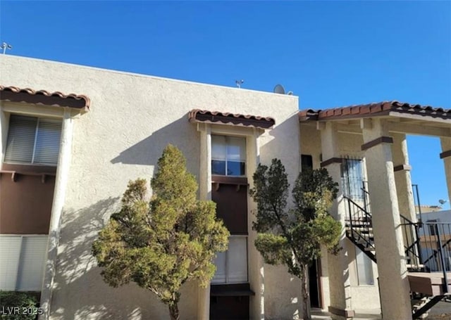 4451 Rich Dr Unit D, Las Vegas, NV 89102 - view of property exterior featuring stairway, stucco siding, and a tiled roof