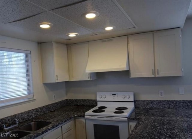 4451 Rich Dr Unit D, Las Vegas, NV 89102 - kitchen with white electric range, range hood, white cabinetry, recessed lighting, and dark stone countertops