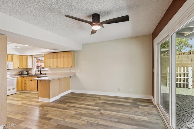 667 Del Prado Dr, Boulder City, NV 89005 - kitchen featuring white appliances, light brown cabinets, a peninsula, ceiling fan, and light wood-type flooring