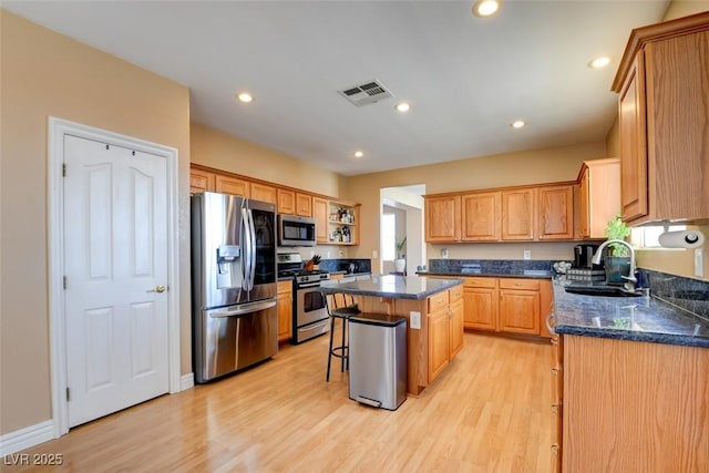 98 Milicity Rd, Henderson, NV 89012 - kitchen with stainless steel appliances, a kitchen island, light wood-style floors, a breakfast bar, and recessed lighting