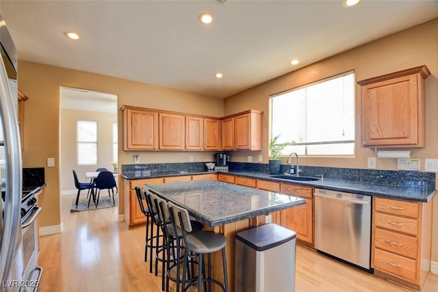 98 Milicity Rd, Henderson, NV 89012 - kitchen with appliances with stainless steel finishes, a kitchen breakfast bar, a kitchen island, light wood-style floors, and recessed lighting