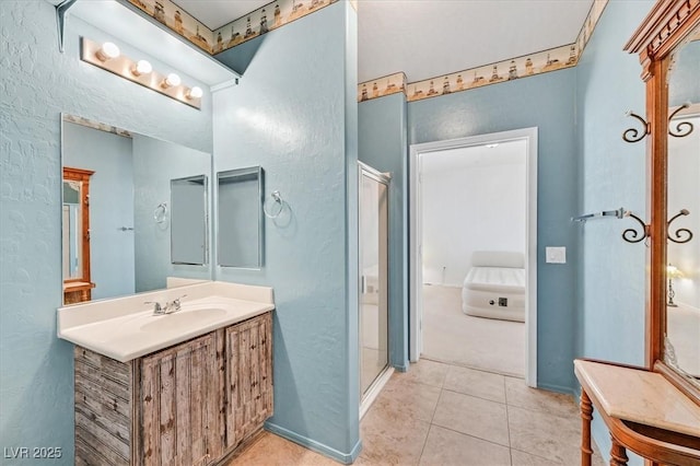 6868 Sky Pointe Dr Unit 1107, Las Vegas, NV 89131 - bathroom featuring a textured wall, vanity, tile patterned flooring, and a stall shower