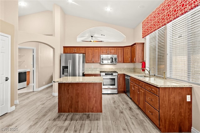 9733 Northern Dancer Dr, Las Vegas, NV 89117 - kitchen with appliances with stainless steel finishes, high vaulted ceiling, a kitchen island, arched walkways, and light stone countertops