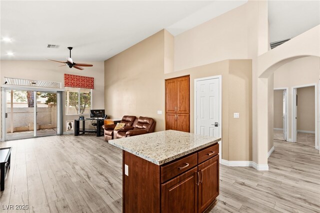 9733 Northern Dancer Dr, Las Vegas, NV 89117 - kitchen with arched walkways, a ceiling fan, high vaulted ceiling, light wood-type flooring, and open floor plan