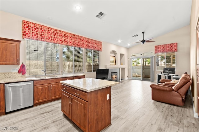 9733 Northern Dancer Dr, Las Vegas, NV 89117 - kitchen featuring dishwasher, a glass covered fireplace, open floor plan, a ceiling fan, and brown cabinets