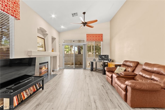9733 Northern Dancer Dr, Las Vegas, NV 89117 - living area featuring a ceiling fan, a tiled fireplace, wood finished floors, and vaulted ceiling