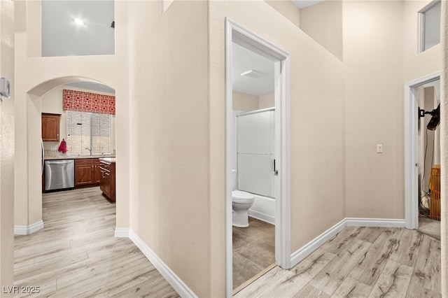 9733 Northern Dancer Dr, Las Vegas, NV 89117 - corridor with light wood-style flooring, arched walkways, and a high ceiling