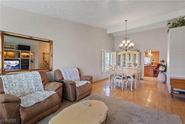 3361 Iberia St, Las Vegas, NV 89146 - living room with a chandelier, arched walkways, and light wood-type flooring