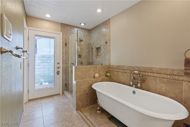 3361 Iberia St, Las Vegas, NV 89146 - full bathroom with tile walls, a soaking tub, a stall shower, tile patterned floors, and recessed lighting