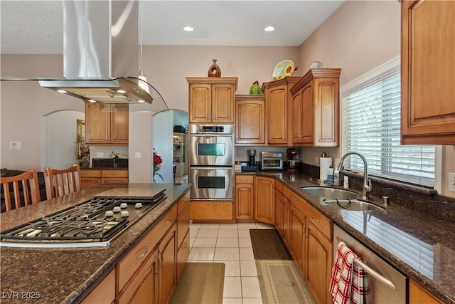 3361 Iberia St, Las Vegas, NV 89146 - kitchen with appliances with stainless steel finishes, extractor fan, arched walkways, light tile patterned floors, and dark stone countertops