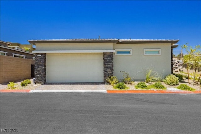 901 Allister Fields Ln, Las Vegas, NV 89138 - view of front of house featuring stucco siding, an attached garage, stone siding, and driveway