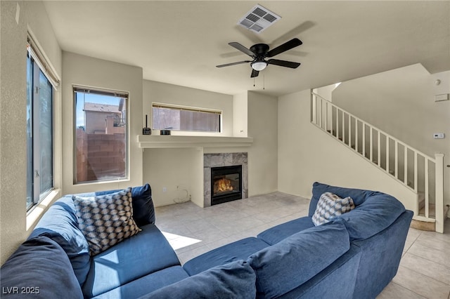 8421 Cheerful Brook Ave, Las Vegas, NV 89143 - tiled living room featuring stairs, plenty of natural light, a ceiling fan, and a fireplace