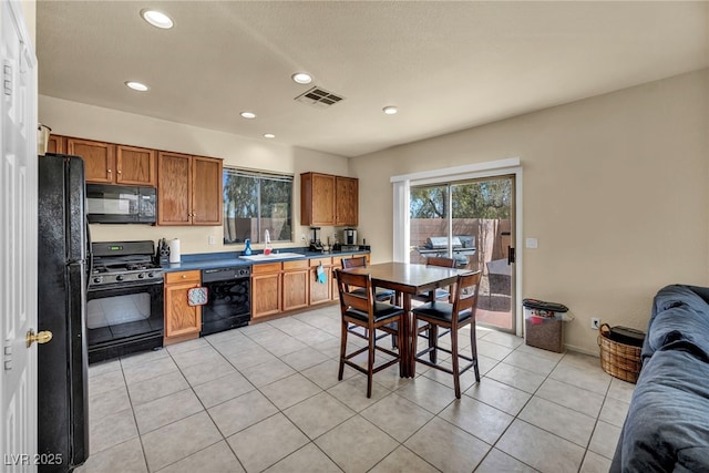 8421 Cheerful Brook Ave, Las Vegas, NV 89143 - kitchen with black appliances, open floor plan, recessed lighting, brown cabinets, and light tile patterned floors