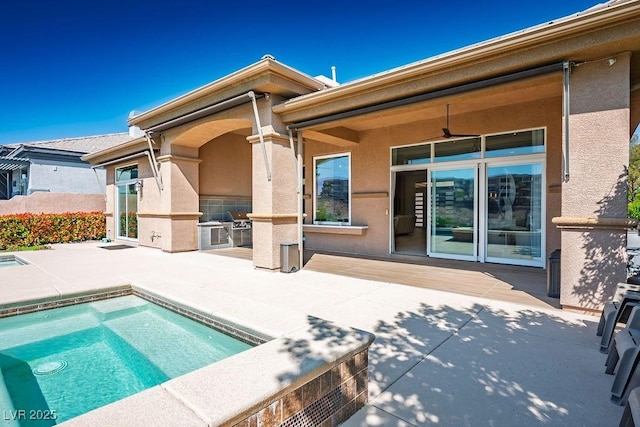 9233 Canyon Mesa Dr, Las Vegas, NV 89144 - back of house featuring an outdoor kitchen, a patio area, stucco siding, and an outdoor pool