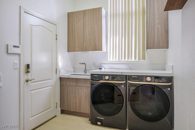 9233 Canyon Mesa Dr, Las Vegas, NV 89144 - laundry room with cabinet space, washing machine and clothes dryer, and light wood-style floors