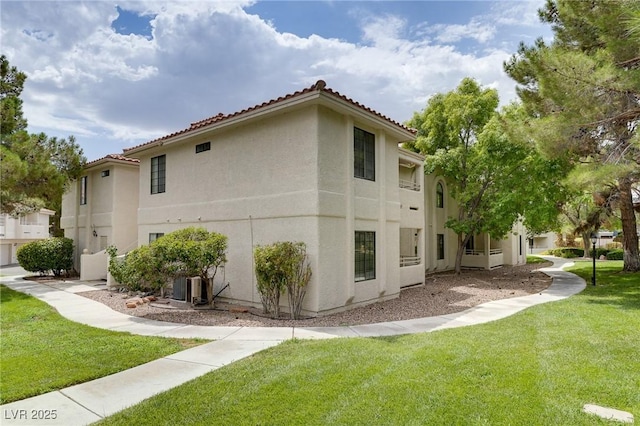 2633 S Durango Dr Unit 202, Las Vegas, NV 89117 - view of home's exterior featuring stucco siding, a tiled roof, and a lawn