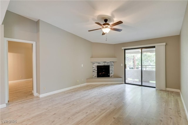 2633 S Durango Dr Unit 202, Las Vegas, NV 89117 - unfurnished living room featuring a ceiling fan, light wood finished floors, and a stone fireplace