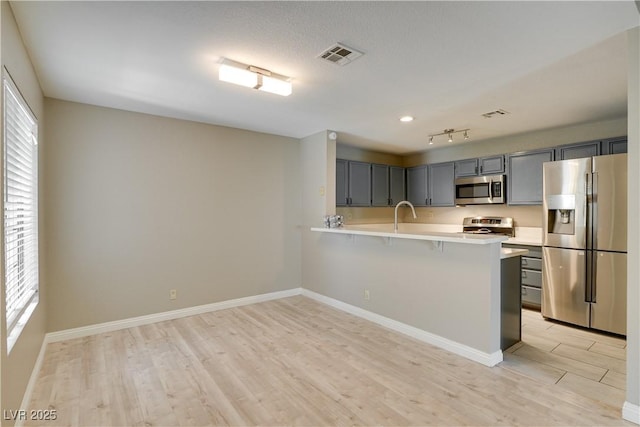 2633 S Durango Dr Unit 202, Las Vegas, NV 89117 - kitchen featuring appliances with stainless steel finishes, light countertops, light wood-style floors, and plenty of natural light