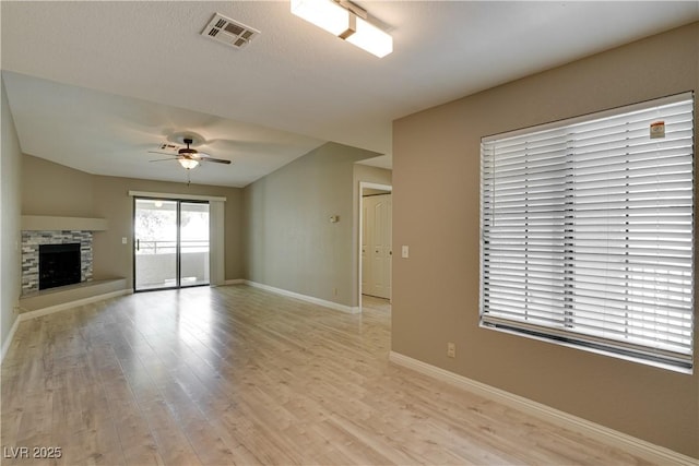 2633 S Durango Dr Unit 202, Las Vegas, NV 89117 - unfurnished living room with a ceiling fan, light wood-type flooring, and a stone fireplace