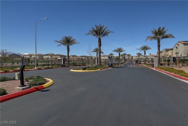 1113 Fragrant Cactus Ct, North Las Vegas, NV 89031 - view of asphalt street with a gate, a residential view, street lighting, and curbs