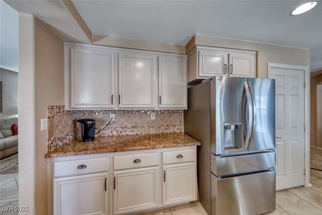 8914 Termoli St, Las Vegas, NV 89123 - kitchen featuring stainless steel fridge with ice dispenser, light stone countertops, tasteful backsplash, and white cabinets
