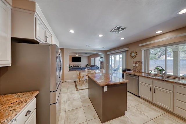 8914 Termoli St, Las Vegas, NV 89123 - kitchen featuring stainless steel appliances, a center island, light stone countertops, recessed lighting, and light tile patterned floors