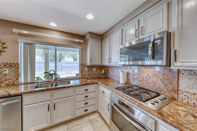 8914 Termoli St, Las Vegas, NV 89123 - kitchen featuring stainless steel appliances, tasteful backsplash, light stone countertops, light tile patterned floors, and white cabinets