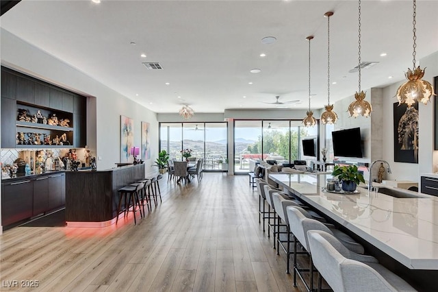527 Serenity Point Dr, Henderson, NV 89012 - indoor bar with light wood-type flooring, a ceiling fan, recessed lighting, hanging light fixtures, and decorative backsplash
