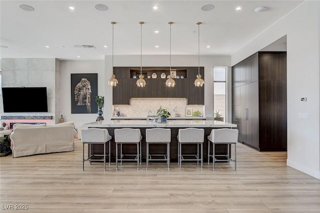 527 Serenity Point Dr, Henderson, NV 89012 - kitchen with modern cabinets, light countertops, a breakfast bar area, recessed lighting, and light wood finished floors