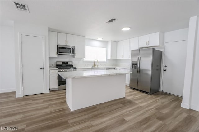 4269 Roanridge Ave, Las Vegas, NV 89120 - kitchen with appliances with stainless steel finishes, a center island, white cabinetry, and light wood finished floors
