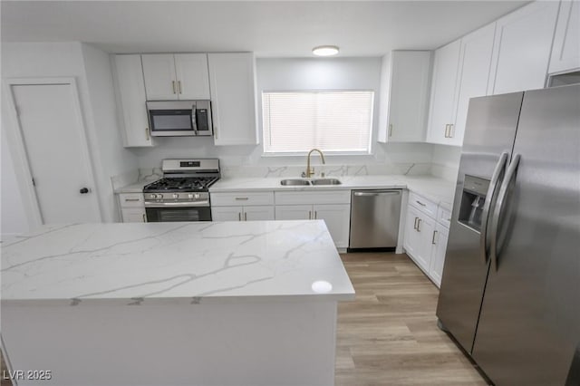 4269 Roanridge Ave, Las Vegas, NV 89120 - kitchen featuring stainless steel appliances, white cabinetry, light wood finished floors, and light stone countertops