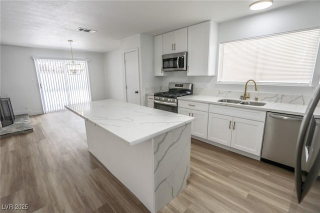 4269 Roanridge Ave, Las Vegas, NV 89120 - kitchen with appliances with stainless steel finishes, light wood-type flooring, a kitchen island, and plenty of natural light