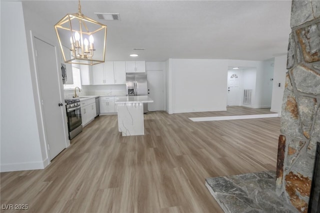4269 Roanridge Ave, Las Vegas, NV 89120 - kitchen with appliances with stainless steel finishes, light countertops, white cabinetry, and light wood finished floors