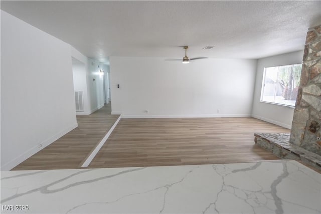 4269 Roanridge Ave, Las Vegas, NV 89120 - unfurnished living room featuring light wood-style flooring, a ceiling fan, and a textured ceiling