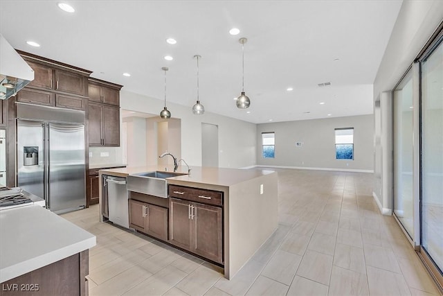 2170 Monte Bianco Pl, Henderson, NV 89044 - kitchen with stainless steel appliances, light countertops, dark brown cabinets, a kitchen island with sink, and recessed lighting