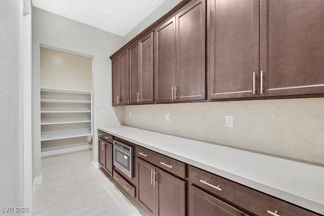 2170 Monte Bianco Pl, Henderson, NV 89044 - kitchen featuring stainless steel microwave, light countertops, dark brown cabinets, and light tile patterned floors