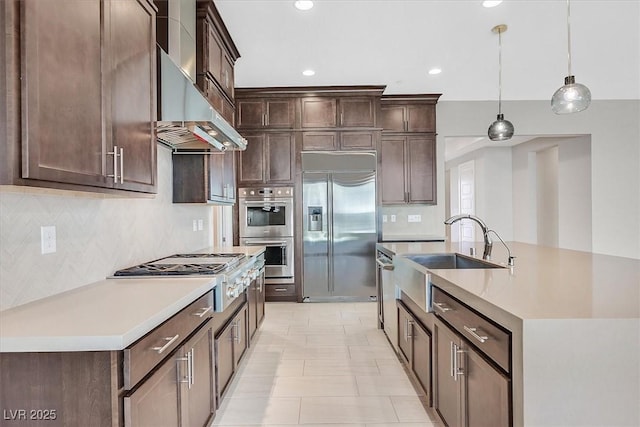 2170 Monte Bianco Pl, Henderson, NV 89044 - kitchen with appliances with stainless steel finishes, dark brown cabinets, backsplash, an island with sink, and recessed lighting
