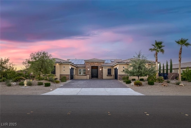 274 Chartan Ave, Las Vegas, NV 89183 - mediterranean / spanish home with a garage, stucco siding, a tiled roof, decorative driveway, and solar panels