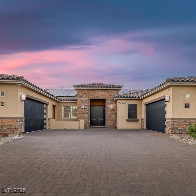 274 Chartan Ave, Las Vegas, NV 89183 - view of front of property featuring a garage, stone siding, and decorative driveway