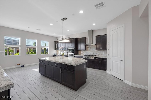 274 Chartan Ave, Las Vegas, NV 89183 - kitchen featuring wall chimney range hood, appliances with stainless steel finishes, wood tiled floors, decorative backsplash, and recessed lighting