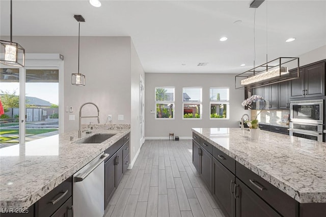 274 Chartan Ave, Las Vegas, NV 89183 - kitchen featuring appliances with stainless steel finishes, light stone counters, light wood finished floors, decorative light fixtures, and recessed lighting
