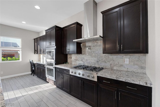 274 Chartan Ave, Las Vegas, NV 89183 - kitchen featuring wall chimney range hood, stainless steel appliances, backsplash, wood tiled floors, and recessed lighting