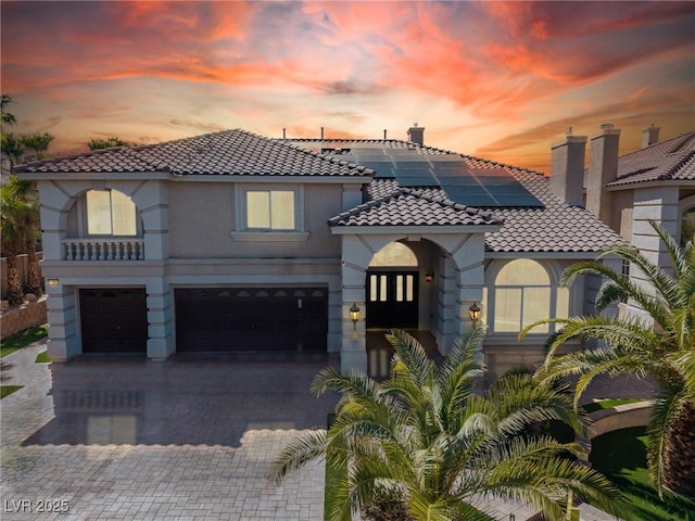 11005 Inverlochy Ct, Las Vegas, NV 89141 - mediterranean / spanish-style home with a tile roof, french doors, stucco siding, decorative driveway, and roof mounted solar panels