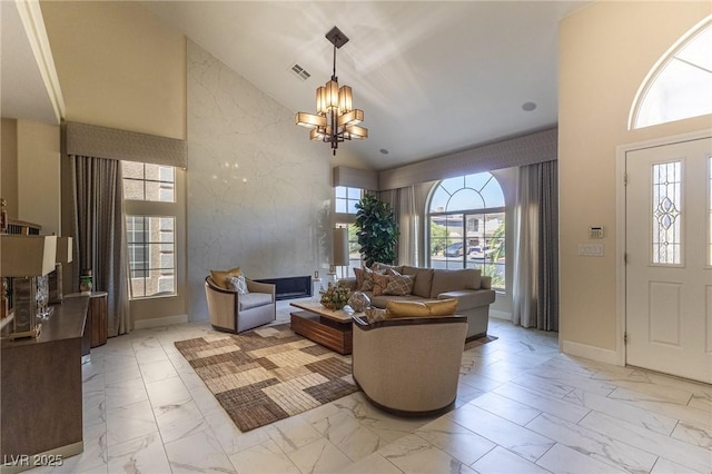 11005 Inverlochy Ct, Las Vegas, NV 89141 - living room with light marble finish floors, high vaulted ceiling, healthy amount of natural light, and a chandelier