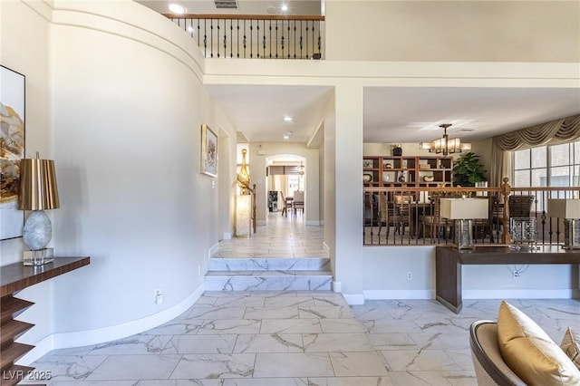 11005 Inverlochy Ct, Las Vegas, NV 89141 - foyer entrance with marble finish floors, arched walkways, a chandelier, and a high ceiling