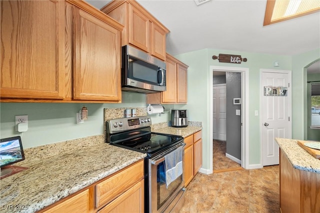 231 Bristle Cone, Pahrump, NV 89048 - kitchen featuring stainless steel appliances, arched walkways, and light stone counters