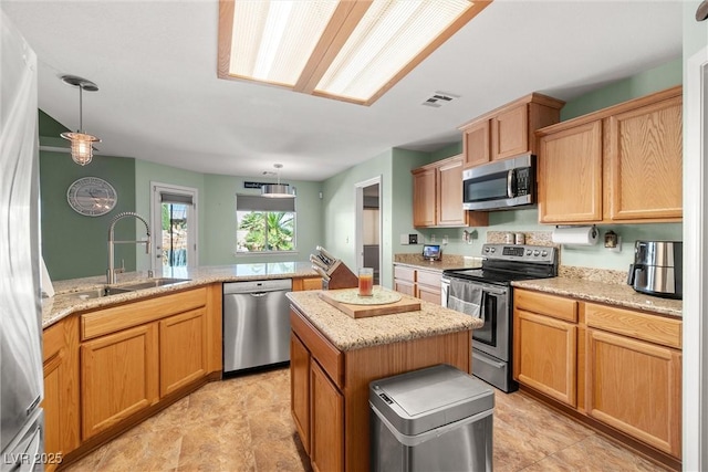 231 Bristle Cone, Pahrump, NV 89048 - kitchen featuring appliances with stainless steel finishes, a kitchen island, hanging light fixtures, and light stone counters