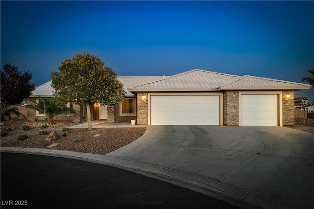 231 Bristle Cone, Pahrump, NV 89048 - view of front of property featuring stone siding, a garage, driveway, and a tiled roof