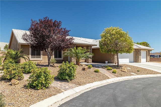 231 Bristle Cone, Pahrump, NV 89048 - view of property hidden behind natural elements featuring driveway, a garage, stucco siding, and stone siding