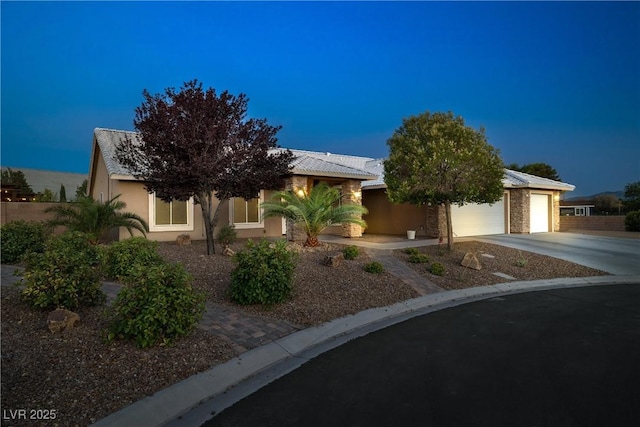 231 Bristle Cone, Pahrump, NV 89048 - view of property hidden behind natural elements featuring concrete driveway, stucco siding, and a garage
